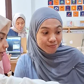Pengajar mendampingi murid belajar di kelas