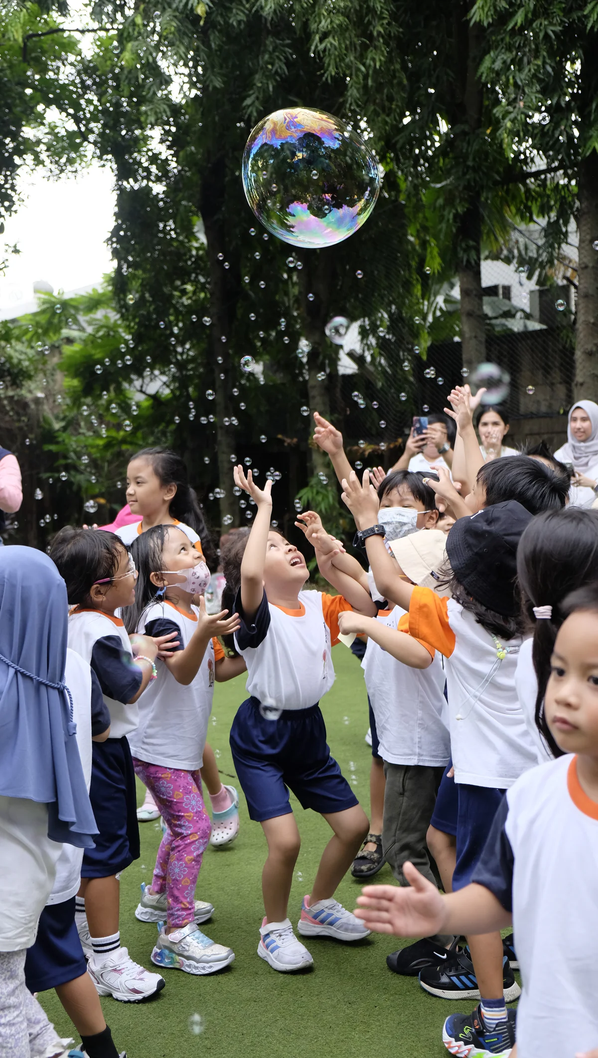 Murid KB/TK bermain gelembung sabun di lapangan